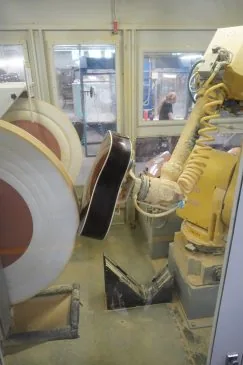 Brazo robótico industrial puliendo guitarras en una línea de fabricación de la fábrica Martin Guitar