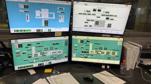 Sistema SCADA de planta de refrigeración con pantallas HMI y panel de control industrial
